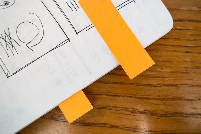 A notebook held closed with a strip of orange tape, ready for recording results